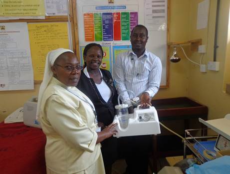 Mariana handing over a suction machine to Sr Stellamaris Mwelu, Administrator and Victor Munyaka of Mutual Mission Hospital, Kitui County, Kenya.