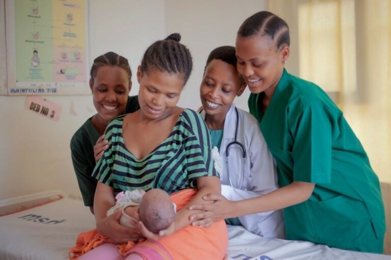 A mother and her baby with healthcare providers.